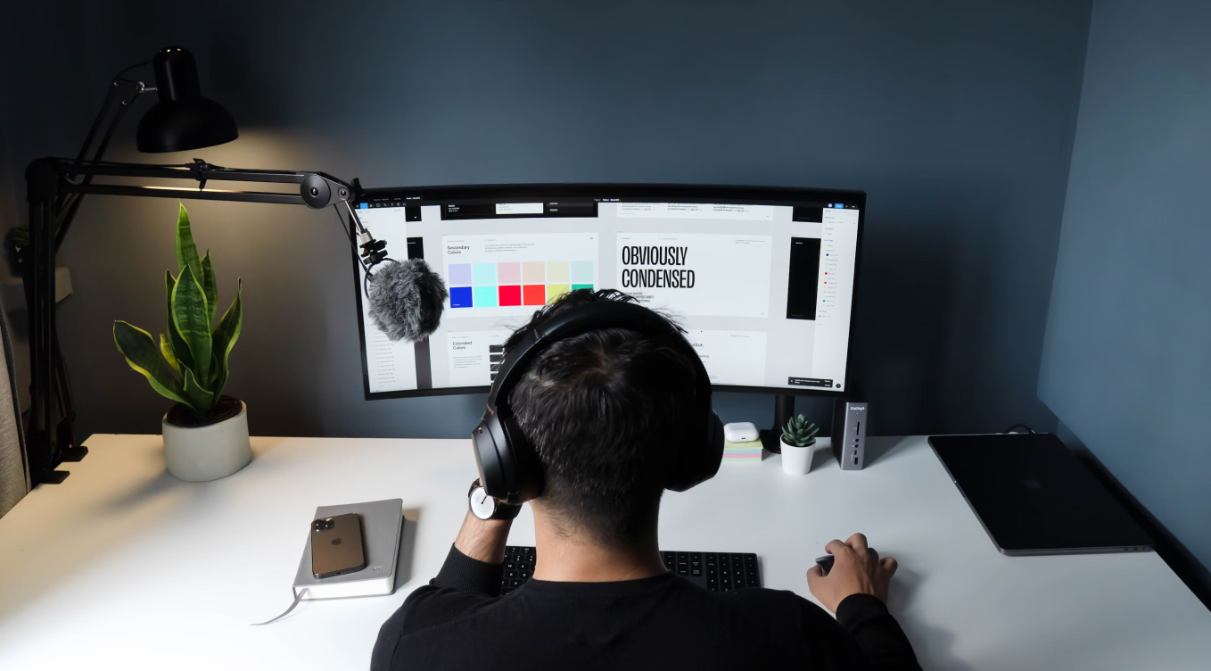 A man sitting at a desk with headphones on.