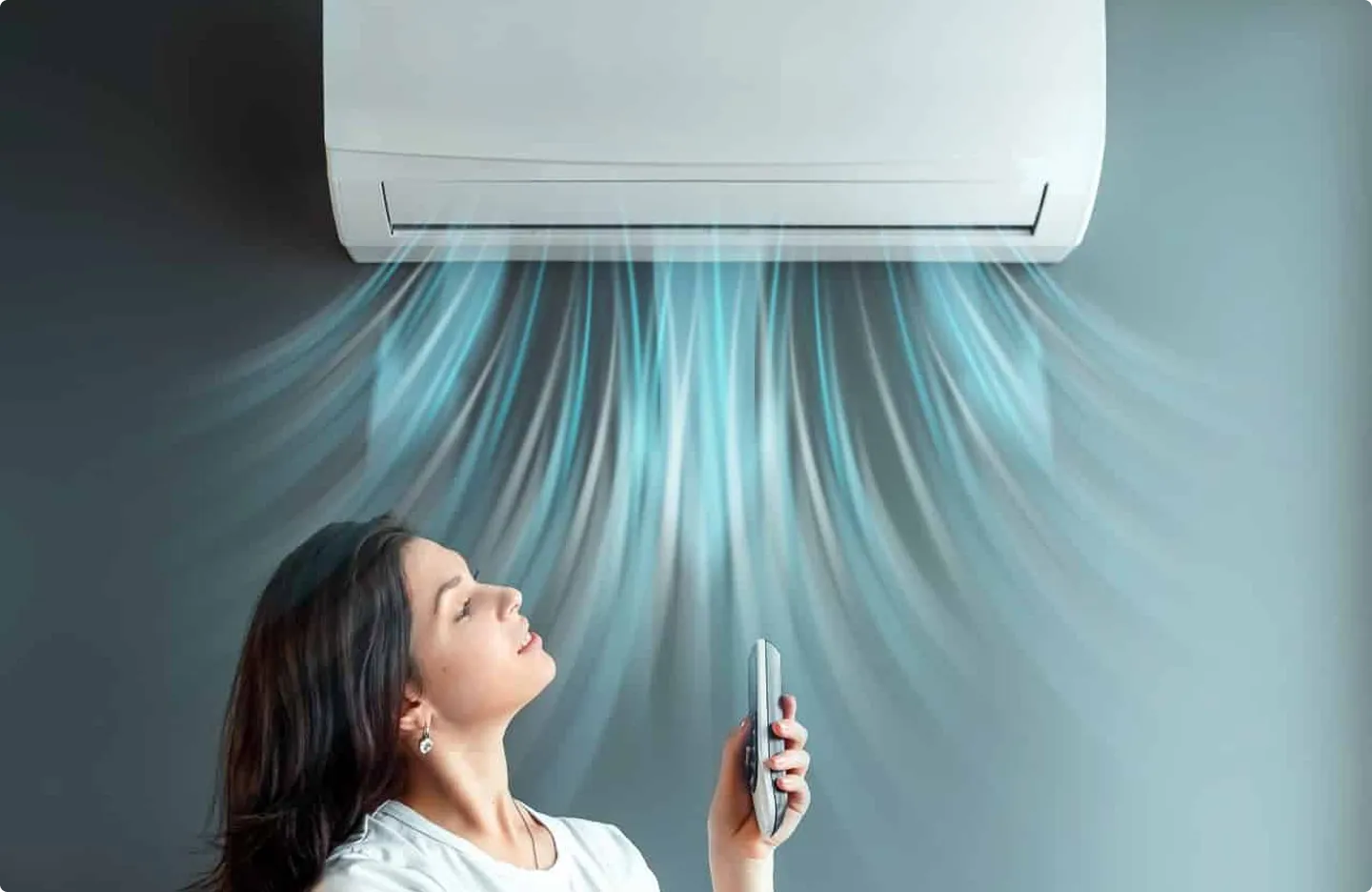 Person enjoying cool air from wall-mounted air conditioning unit