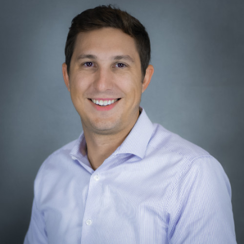 Profile image of managing partner, in suite, smiling