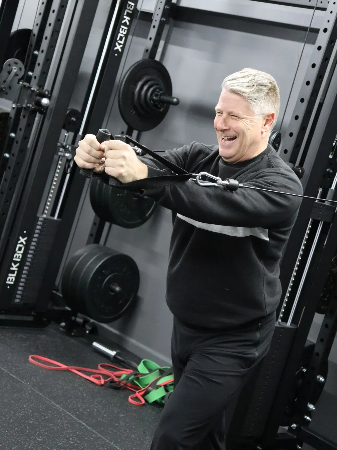 A HUSTLE personal trainer supporting a member doing a chest press
