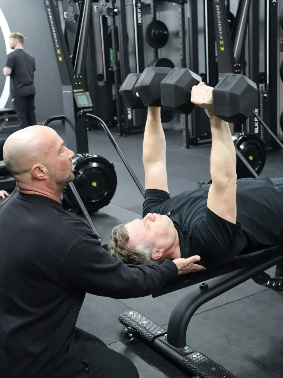 HUSTLE member doing chest press at the gym