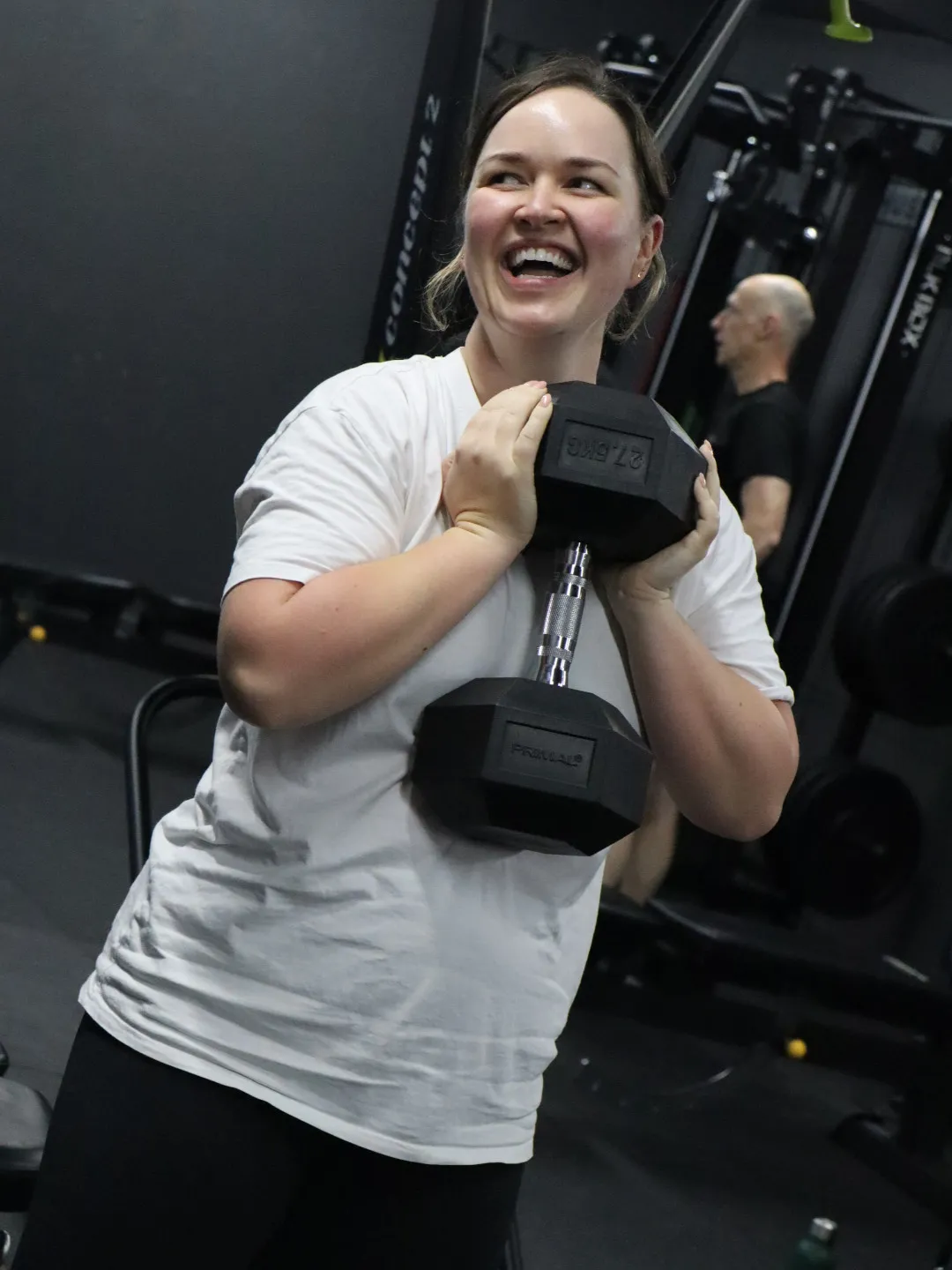 HUSTLE Crawley gym member holding a dumbell smiling