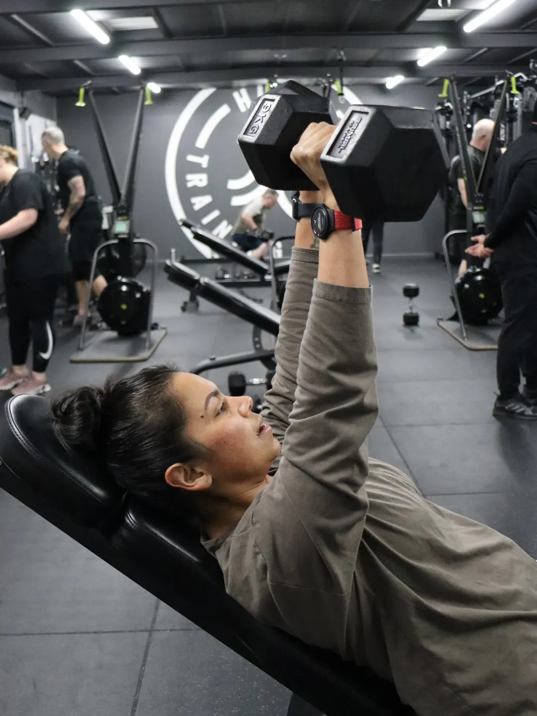 HUSTLE member doing chest press at the gym