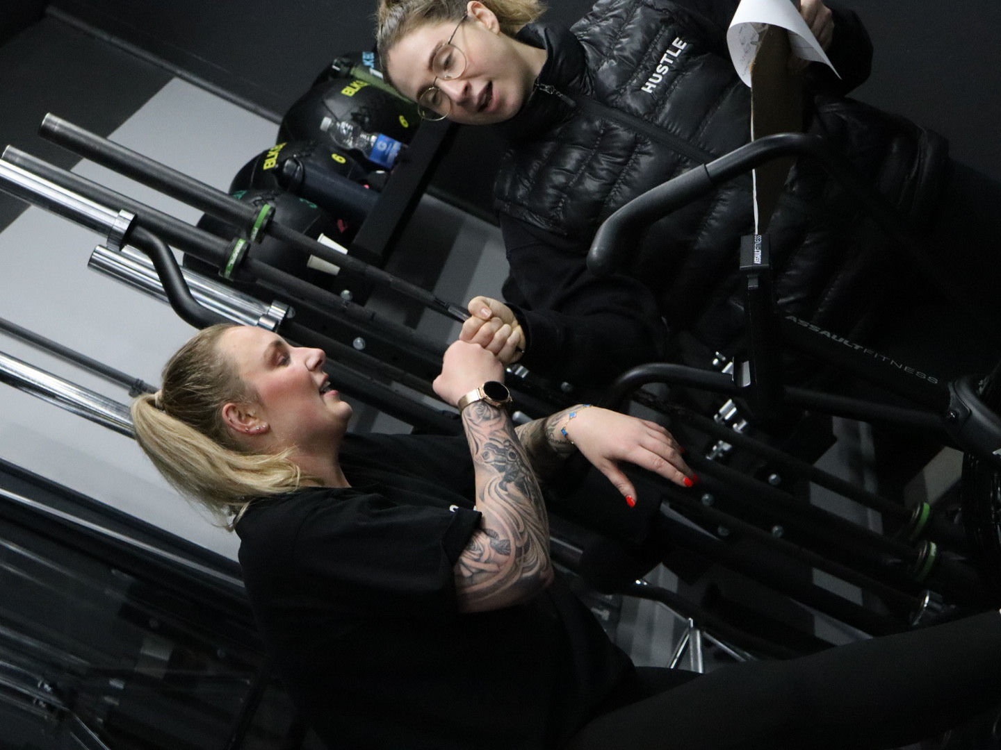 A HUSTLE personal trainer fist pumping a member after a workout