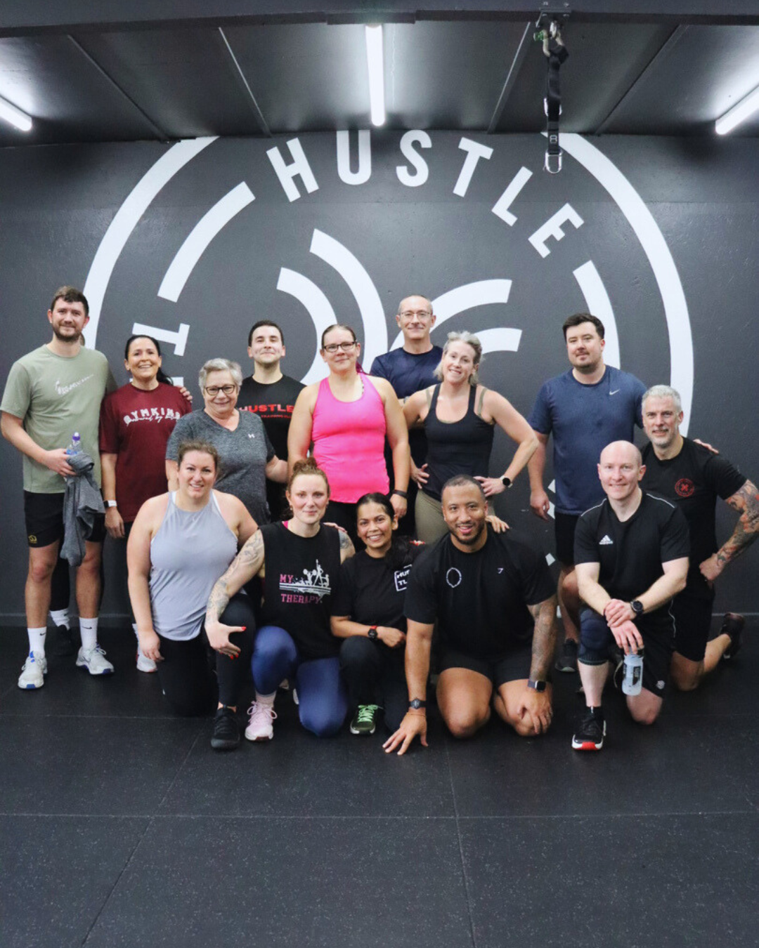 A HUSTLE personal trainer supporting a member doing a chest press