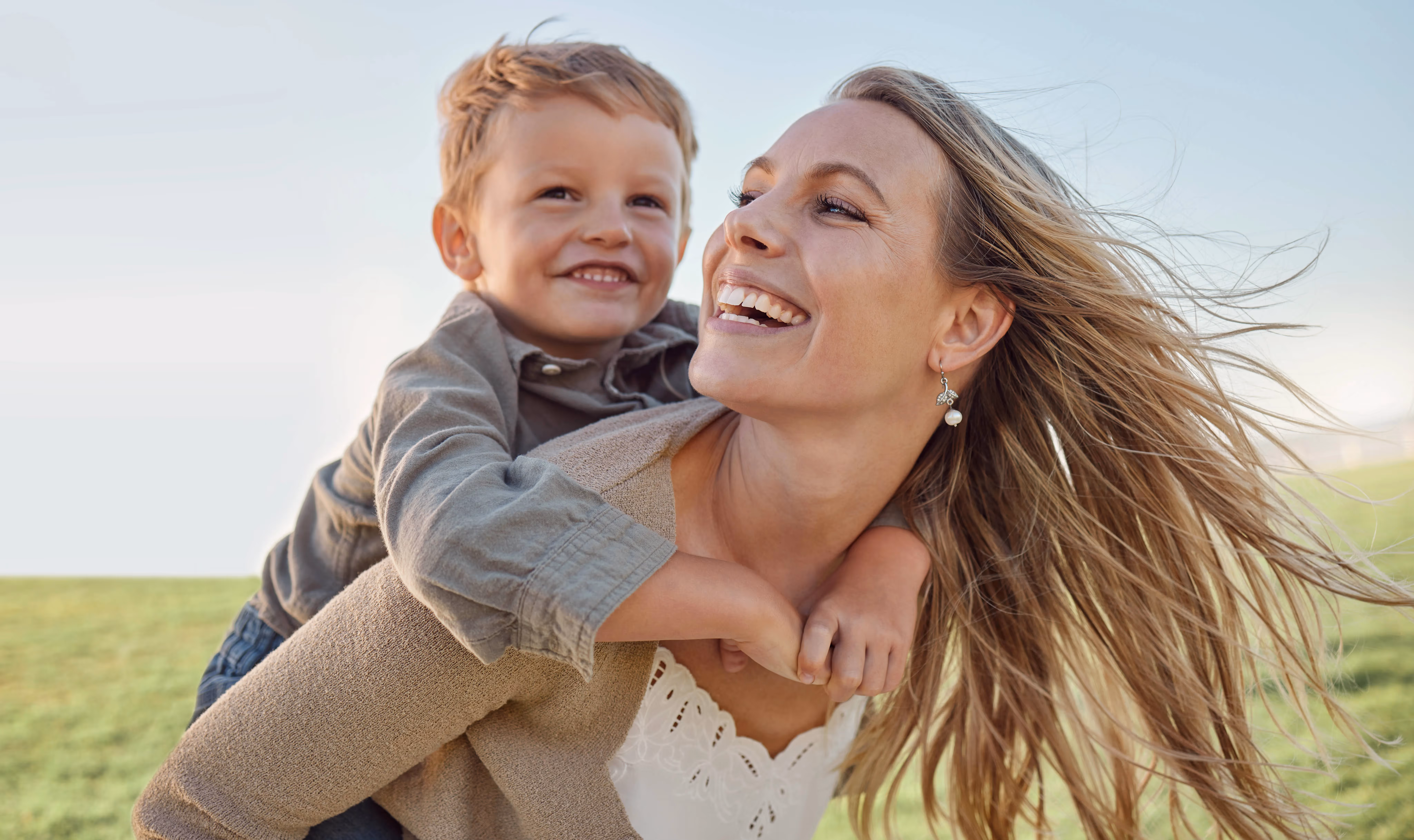 lady laughing with kid on back stock image