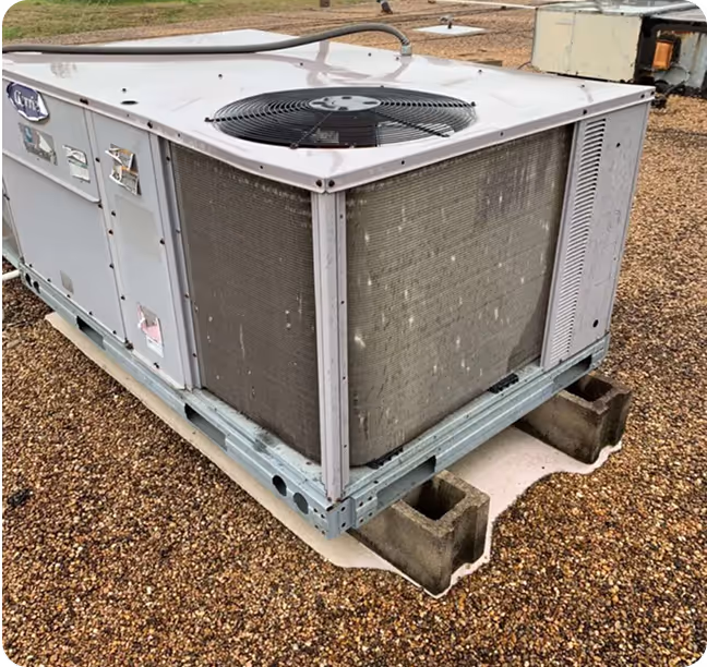 Large commercial air conditioning unit sitting on concrete blocks outdoors