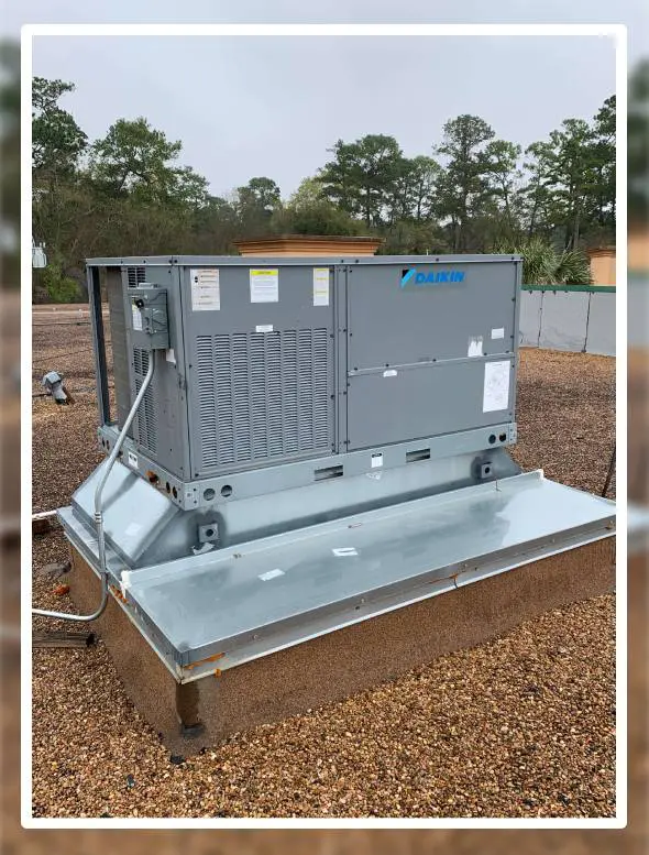 Large Daikin HVAC unit installed on metal platform in wooded area