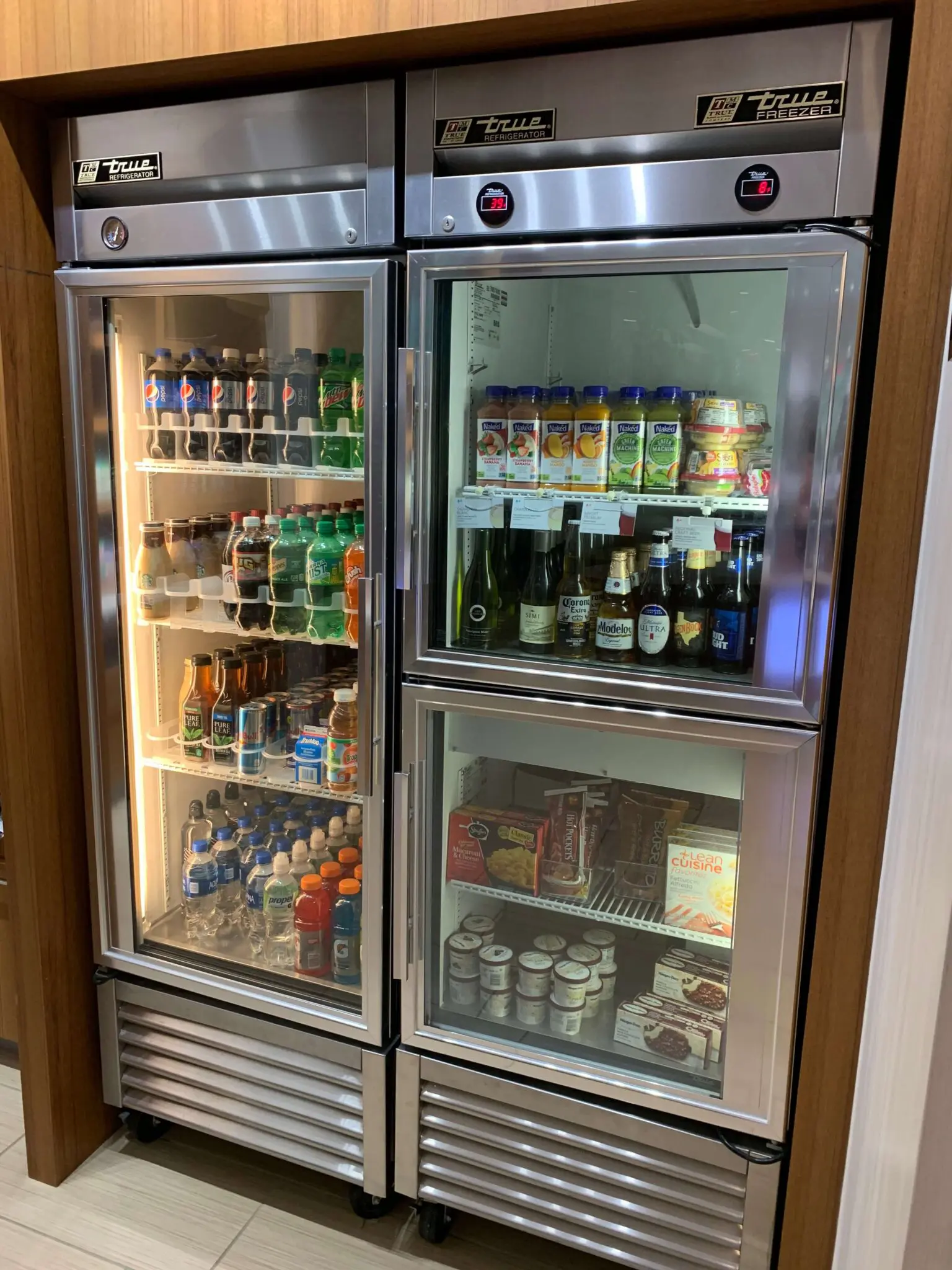 Commercial True refrigerator filled with beverages, juices, and packaged foods