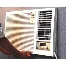 Window air conditioning unit mounted on wall with hand adjusting controls