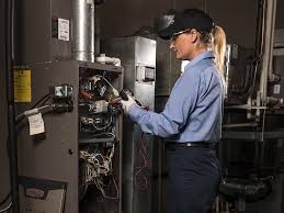Technician in blue uniform inspecting industrial equipment in mechanical room