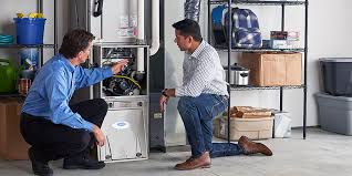Two technicians inspecting a furnace in a utility room with shelving