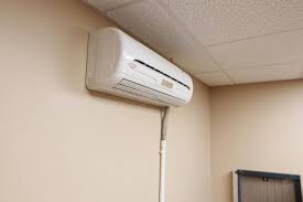 Wall-mounted white air conditioning unit in a neutral-toned room