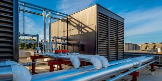 Industrial rooftop with blue pipes, HVAC systems, and glass building