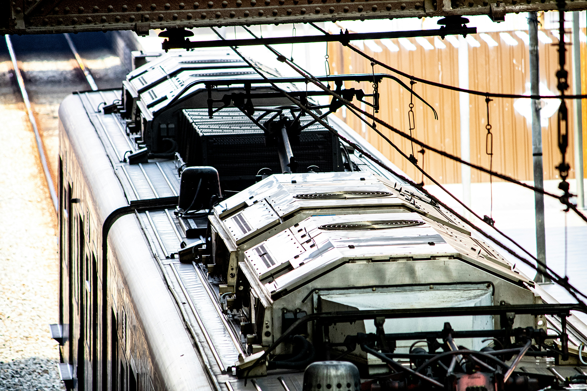 Close-up of train roof with complex mechanical infrastructure and overhead wires