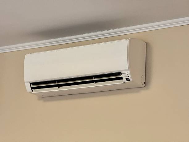 Wall-mounted split-type air conditioning unit in beige and white colors