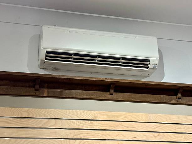 White wall-mounted air conditioning unit above wooden slats