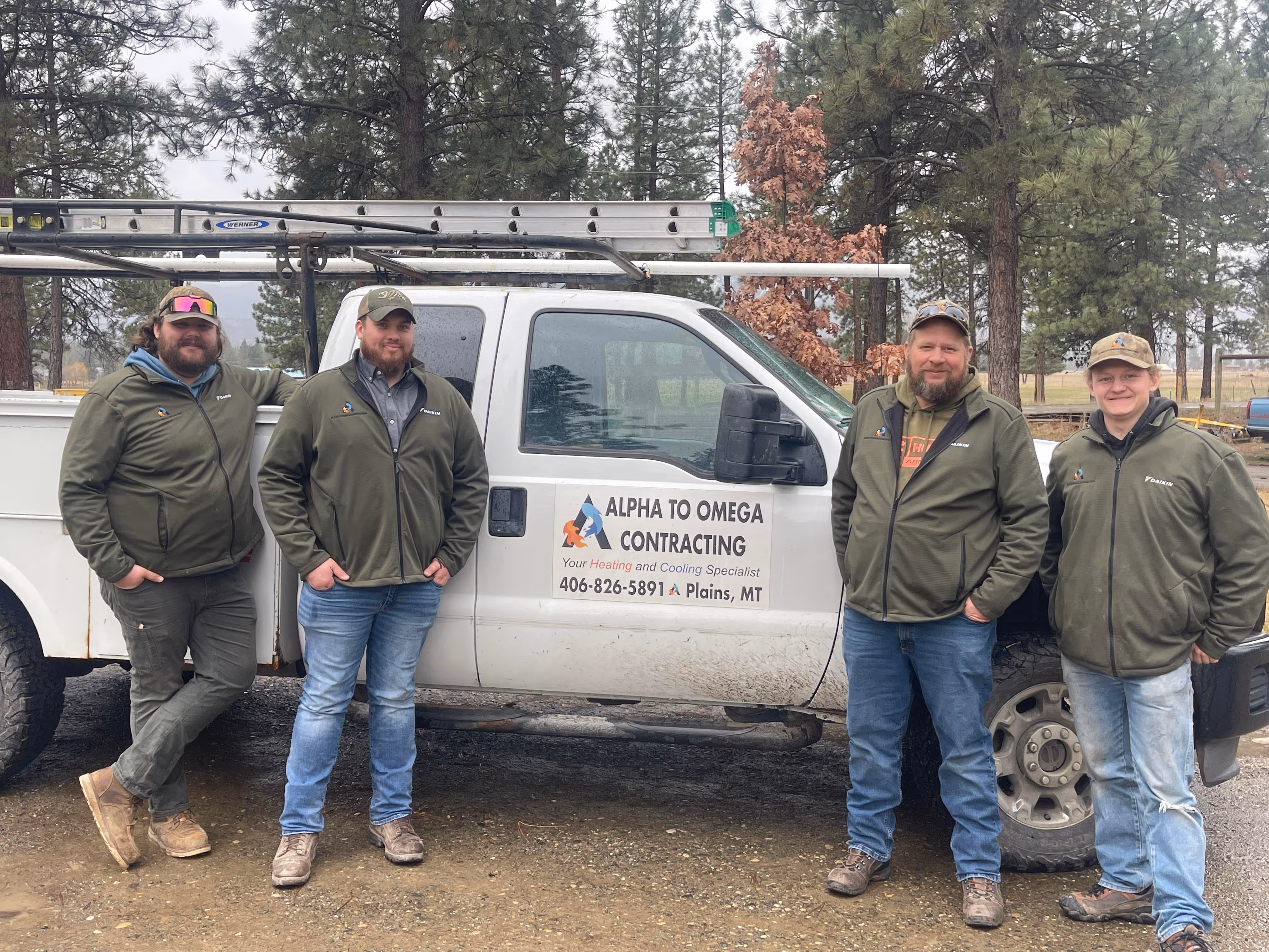A group of men standing next to a white truck.