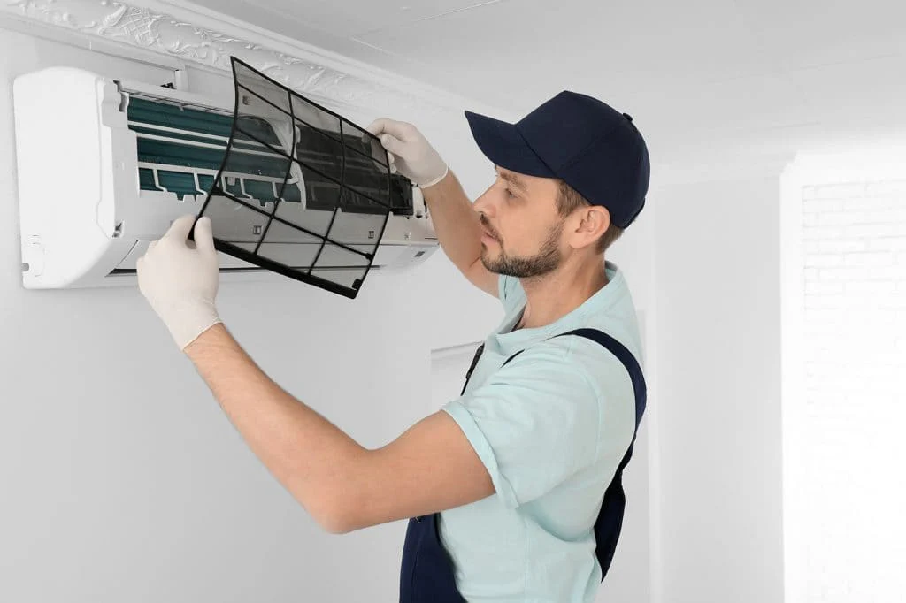 Man fixing an indoor AC unit.