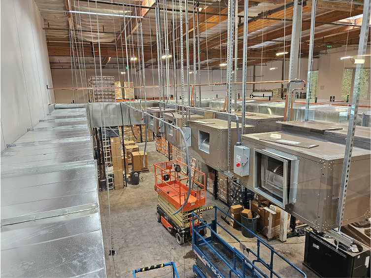 Industrial facility with scissor lifts, machinery, and metal shelving