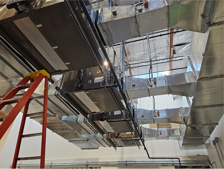 Complex industrial HVAC ductwork and ventilation system with red ladder
