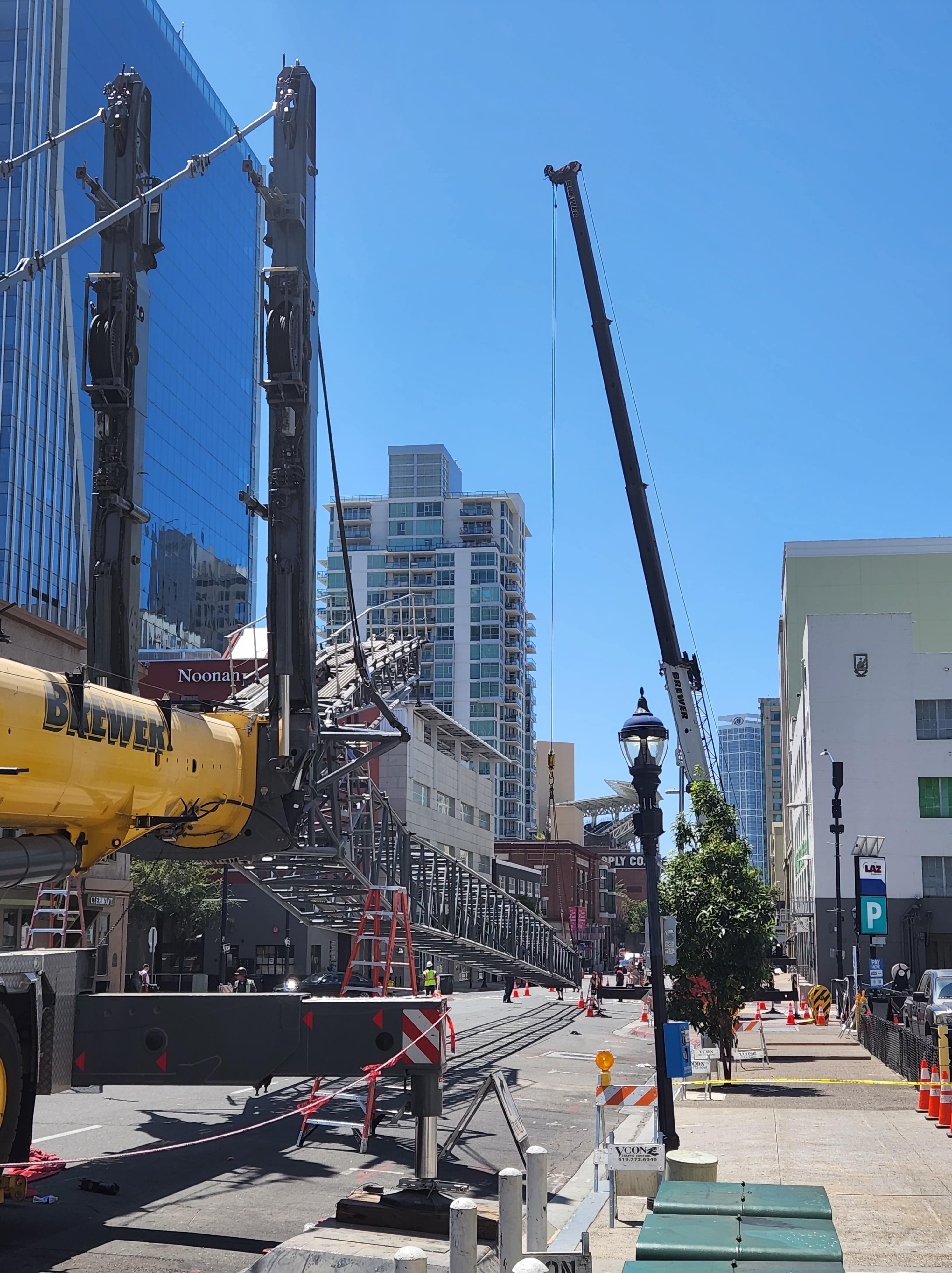 Urban construction site with crane, scaffolding, and city buildings on sunny day