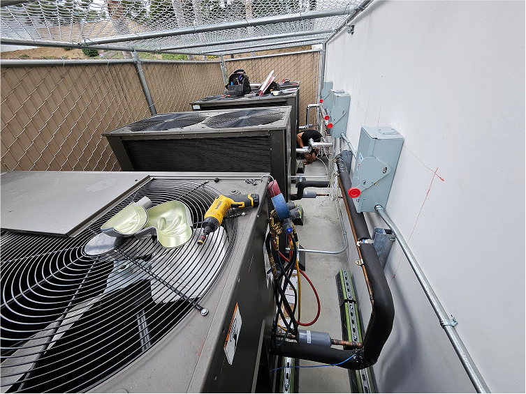 HVAC technician working on air conditioning units and electrical equipment