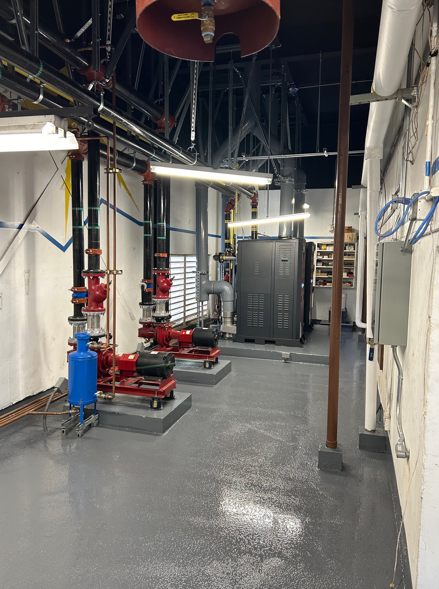 Industrial mechanical room with pumps, pipes, and electrical equipment