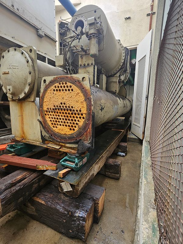Large rusty industrial heat exchanger with perforated tube sheet