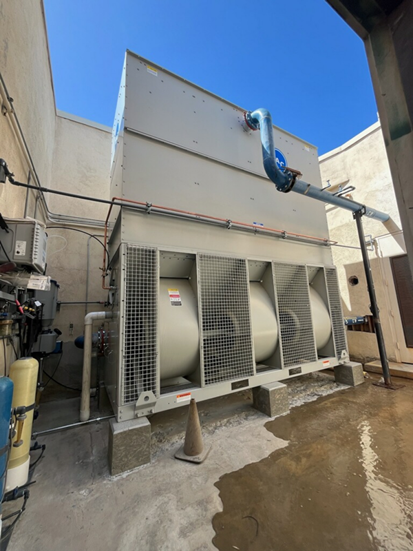 Large industrial cooling system with metal fans against blue sky