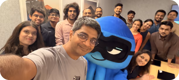 Reo.Dev team gathered for a group selfie with the company mascot in the office.
