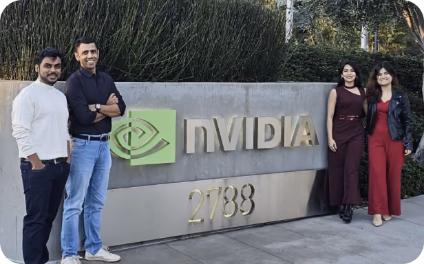 Group photo of four people standing beside the NVIDIA sign and logo outside the company's office at 2788.