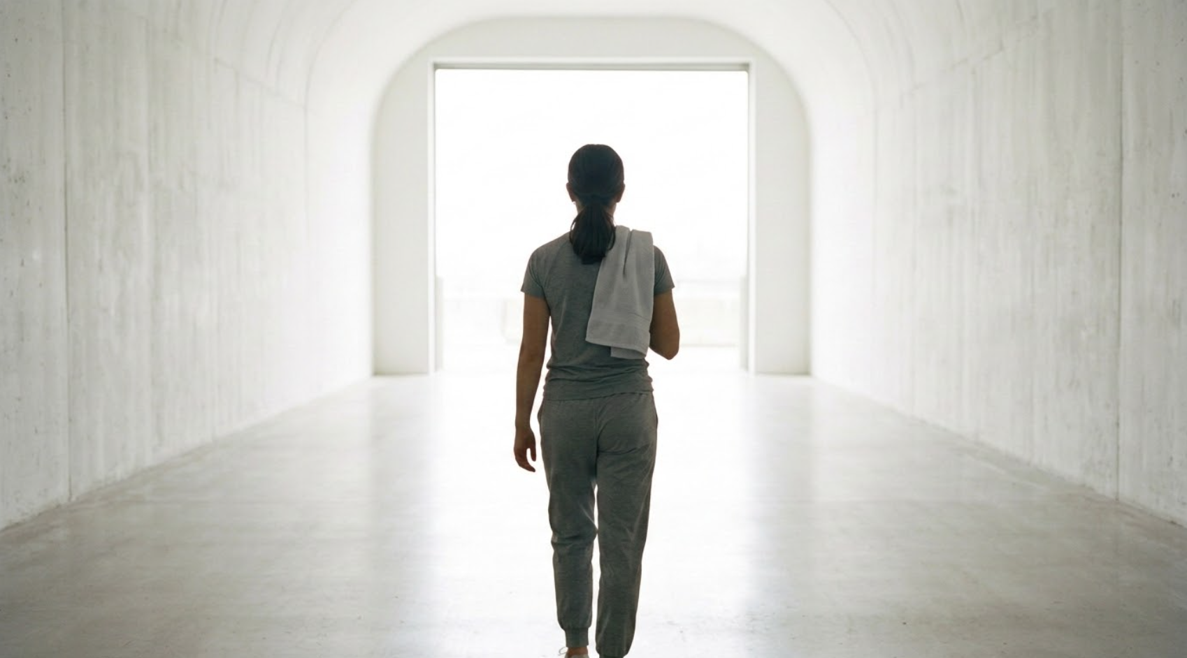 An athlete walking through a tunnel toward the light