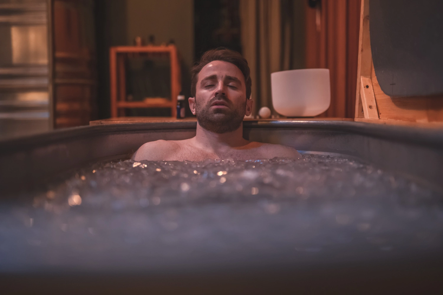 A man laying in an ice bath at Othership