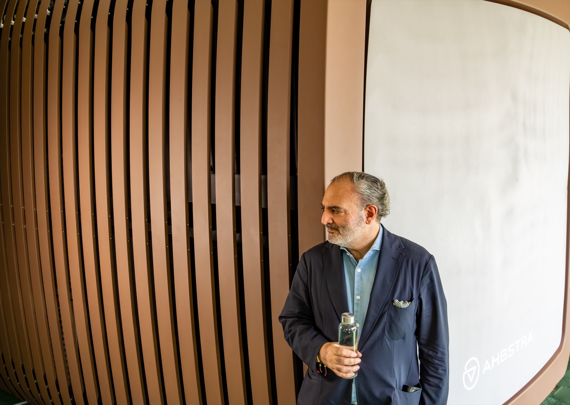 Ahbstra CEO Hashem Arouzi holding a bottle of harvested water beside the ARK