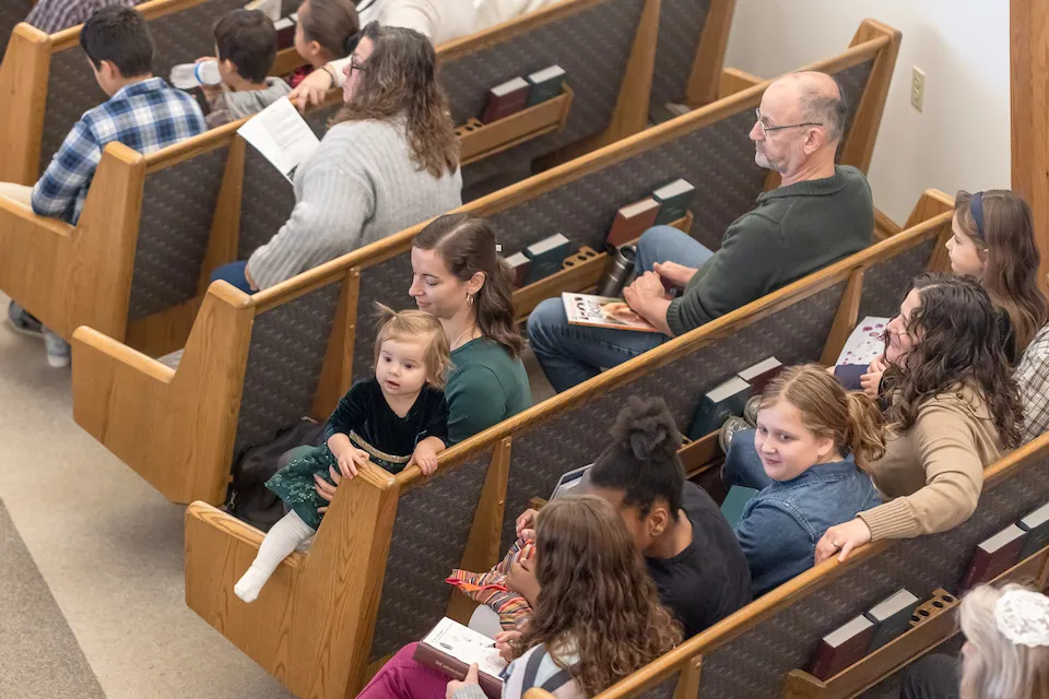 A group of people sitting in pews, waiting for the service to begin.