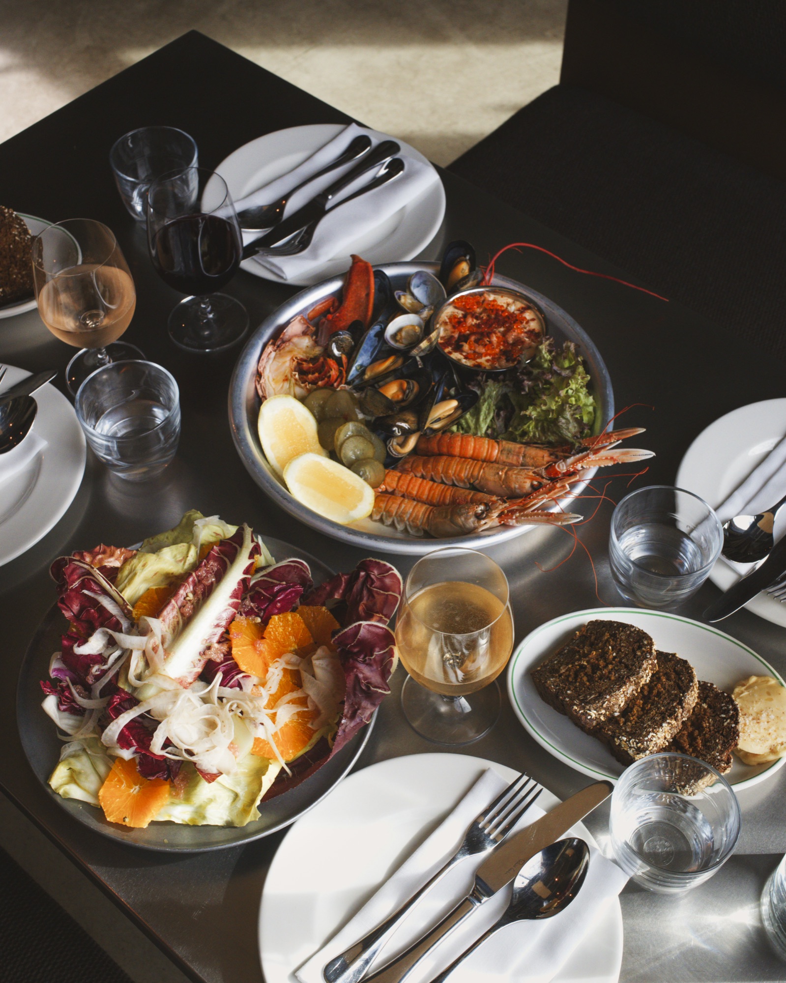 Shellfish platter, radicchio and citrus salad and brown bread on the table at Canal