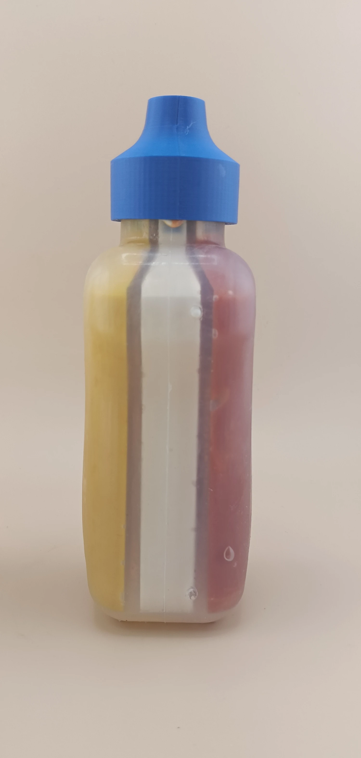 Early clear prototype of the triple-chamber bottle showing the three internal sauce channels