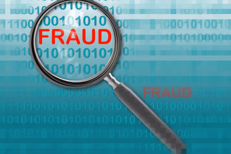 stock photo magnifying glass over word fraud in red