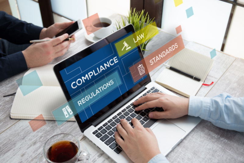 stock photo hands on laptop screen with text compliance regulations standards