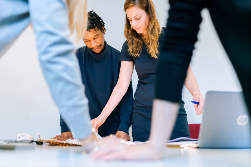 stock photo people standing over table having discussion