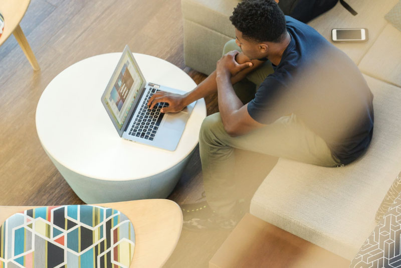 stock photo person sitting at table with laptop from above
