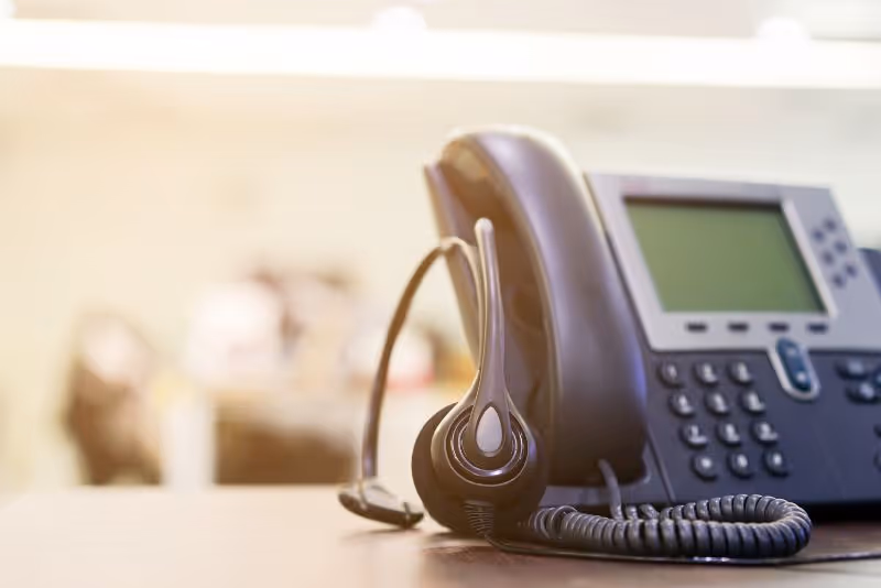stock photo business phone on desk with headset