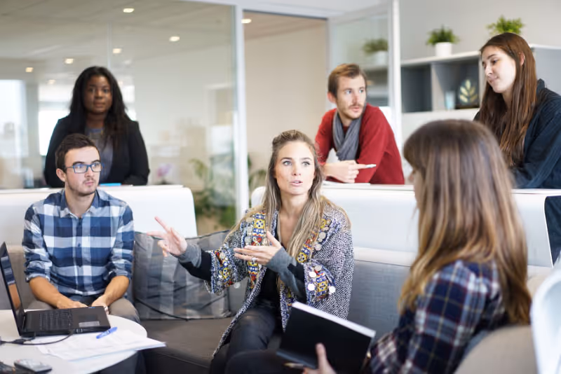 stock photo multiple people gathered around seating area conversing