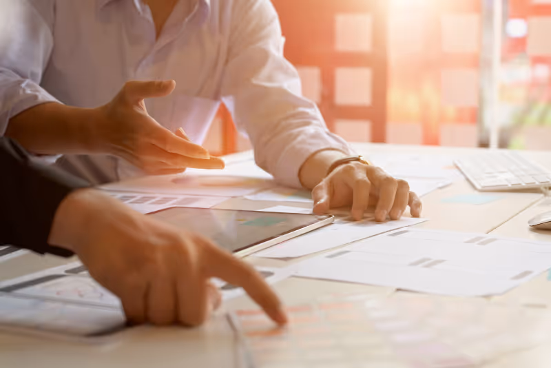 stock photo hands discussing plans on table