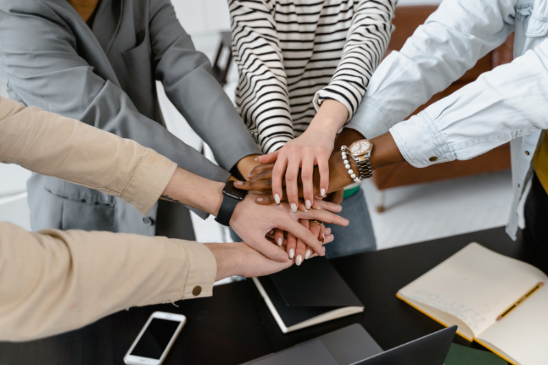 stock photo multiple hands together in pile for cheer