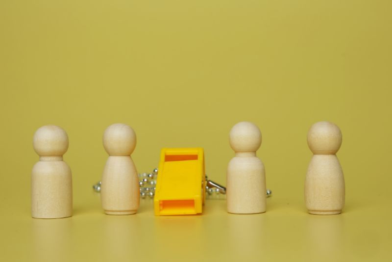 stock photo wooden people figures with whistle in middle
