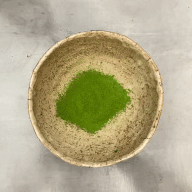 Persona vertiendo agua sobre polvo de matcha