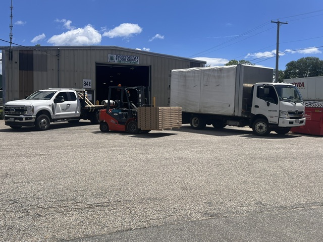 Independence Flooring & Supply warehouse loading dock with delivery trucks and forklift