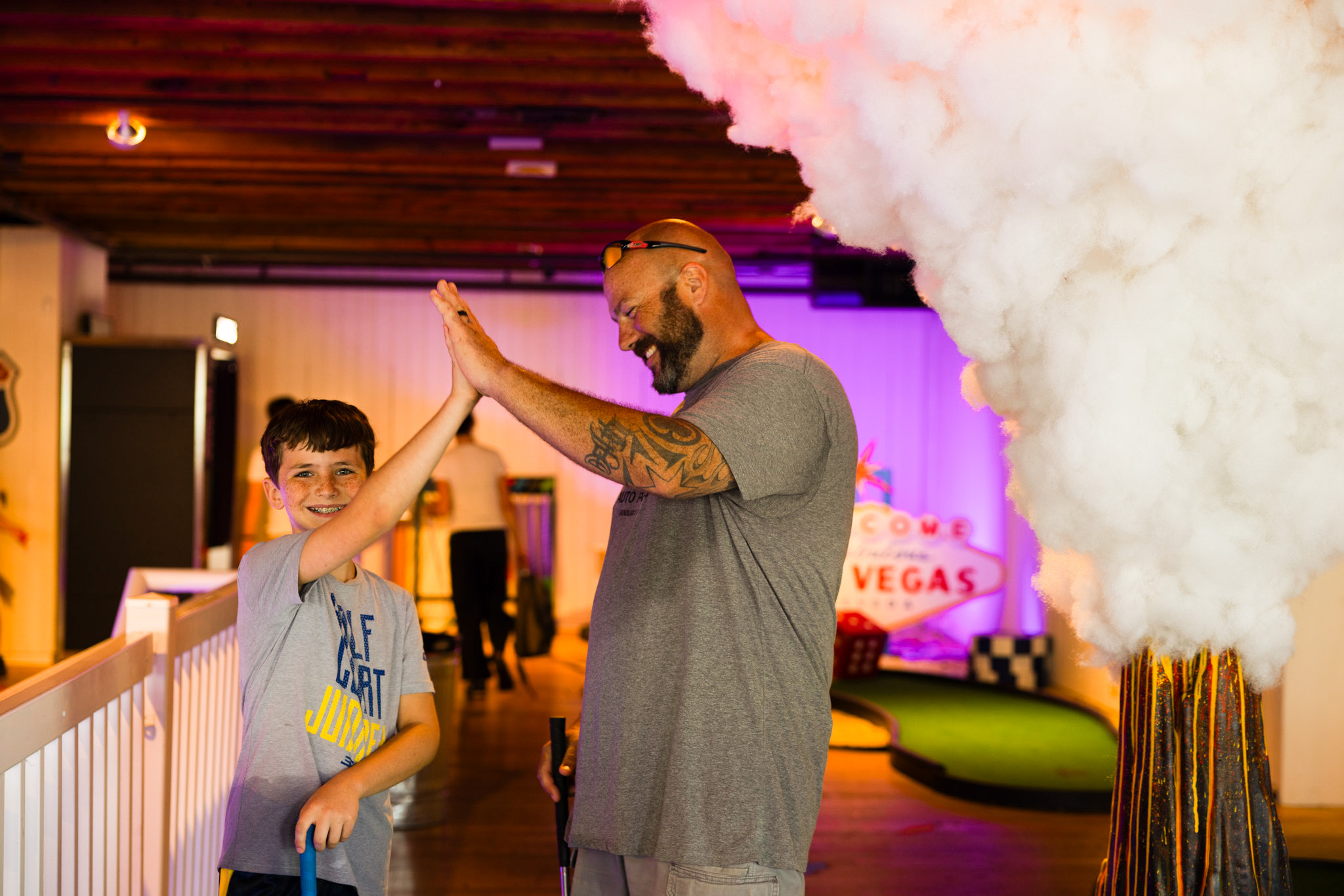 Father and son high-fiving next to Las Vegas hole
